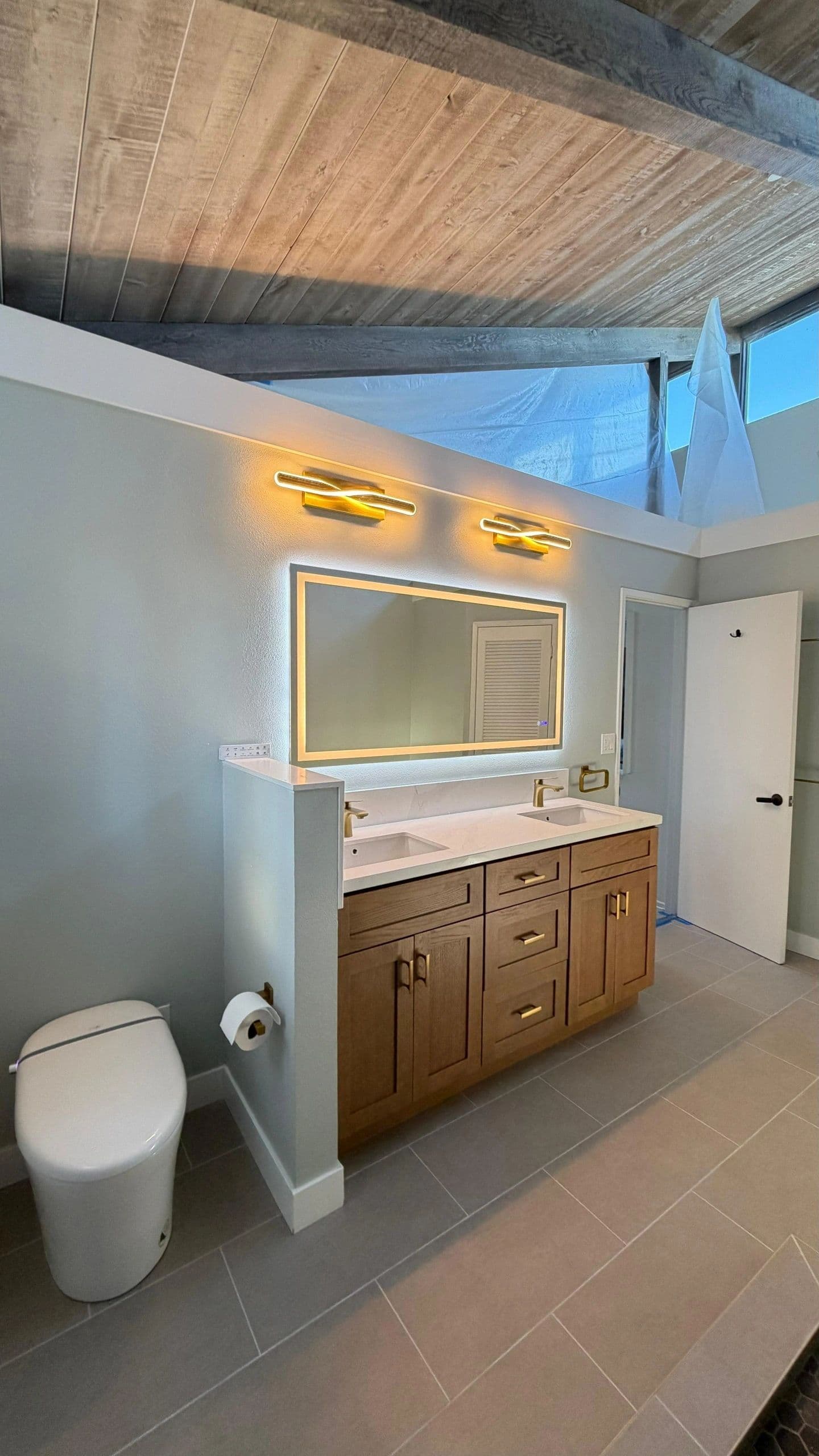 Mid-century bathroom remodel with wood ceiling, walnut vanity and brass fixtures in Del Mar